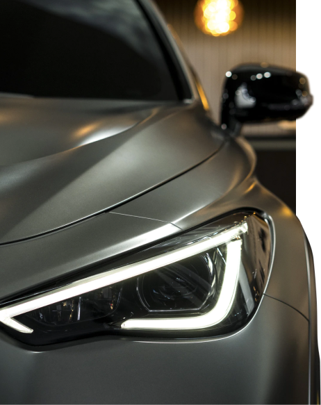 Close up image of a car headlight and wing mirror